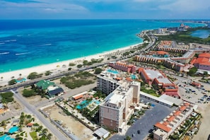 An aerial view of a coastal resort with multiple buildings, a beach, and a marina.