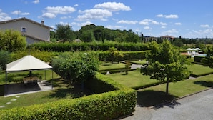 Un jardin agrémenté d’un belvédère, de haies soigneusement taillées et d’un ciel d’un bleu limpide.