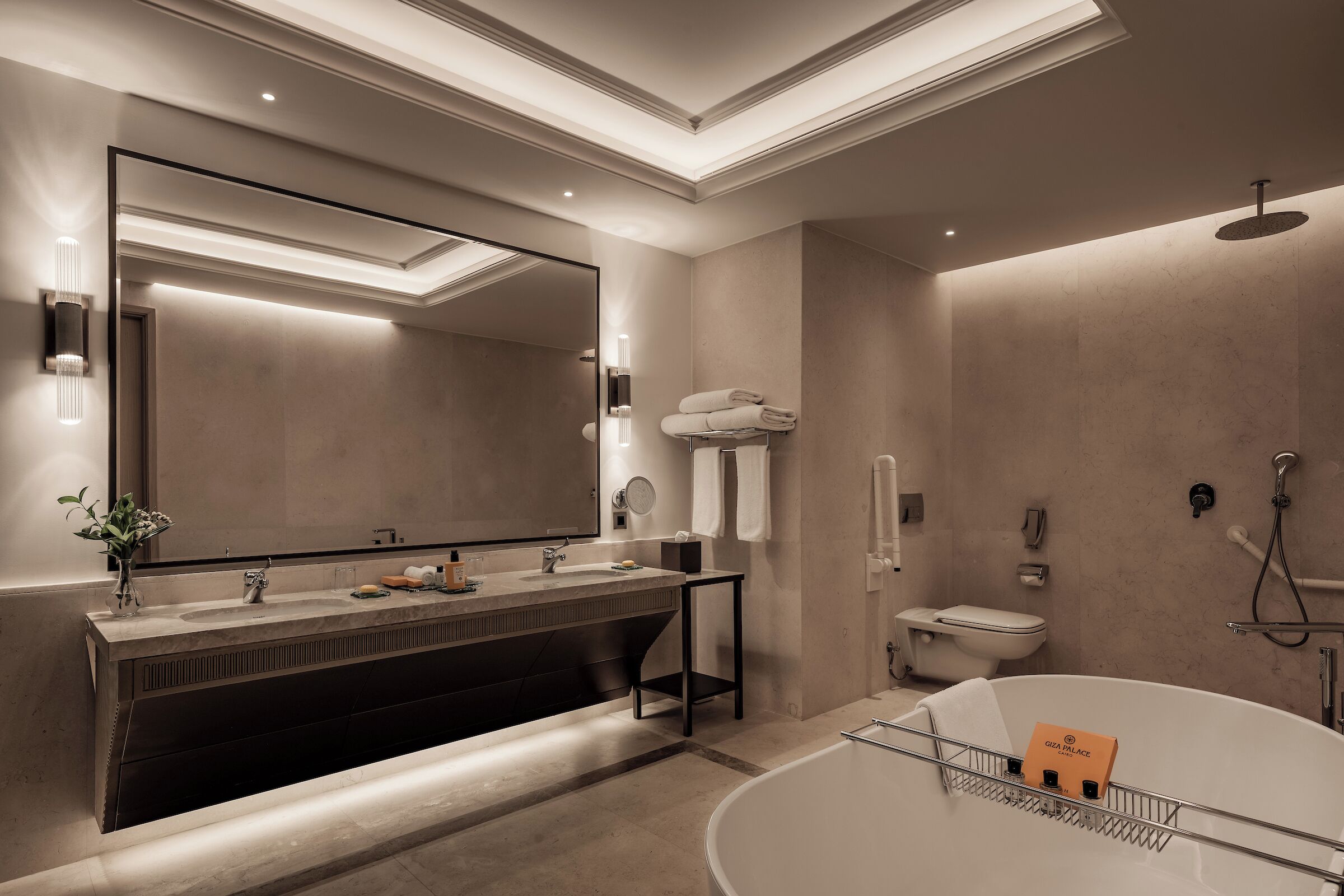 Un baño moderno con un espejo grande, una bañera, un inodoro y una ducha.