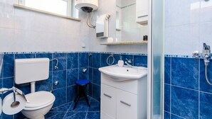 A bathroom with a toilet, sink, and shower.