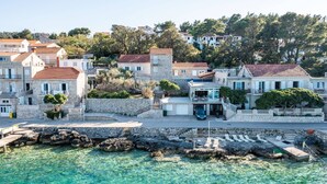 A coastal town with stone buildings, clear waters, and a rocky shoreline.