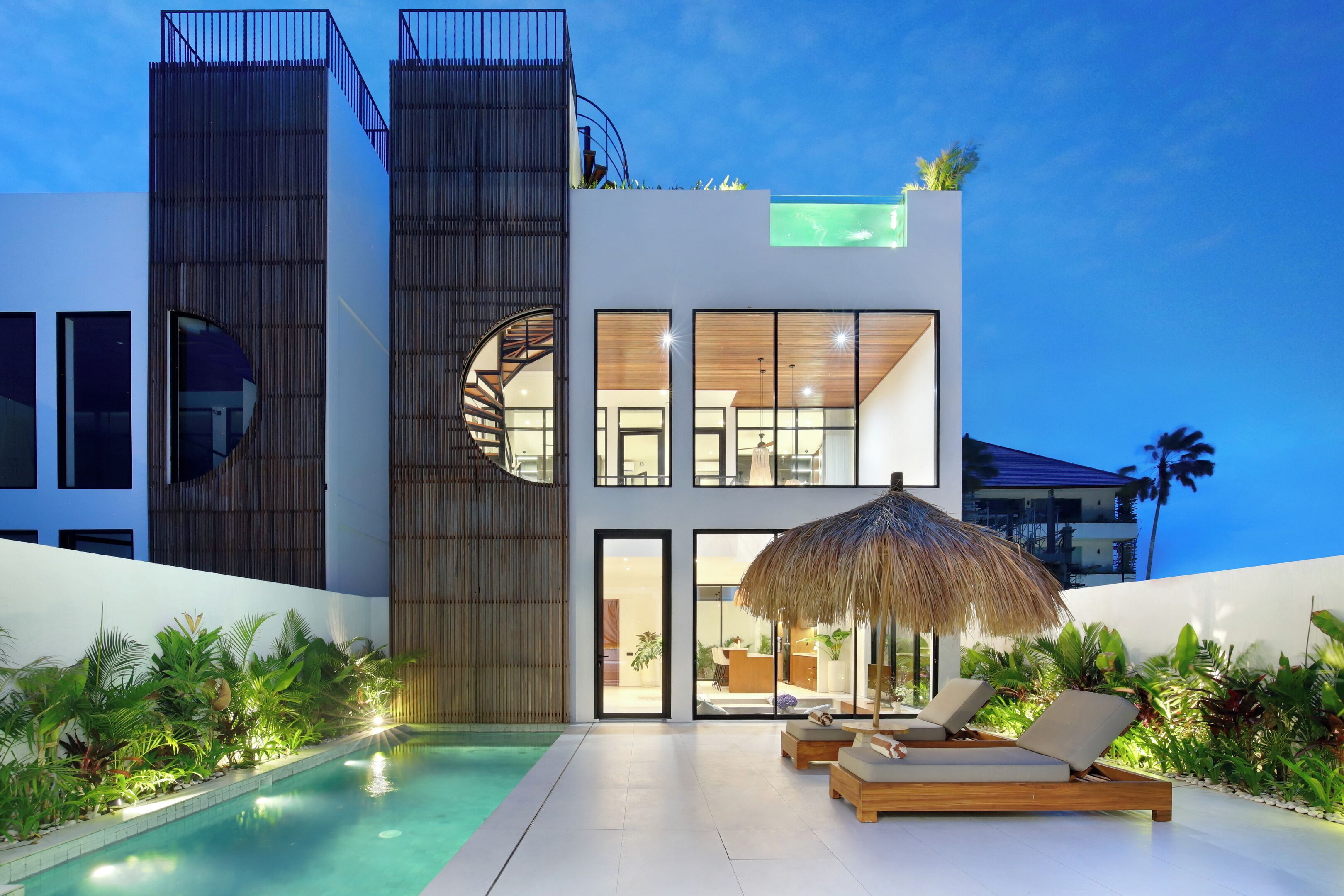 Um edifício moderno com piscina, área de estar e escadaria em espiral.