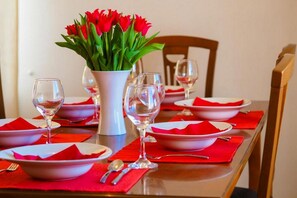 A formal dining experience awaits, complete with fine china, wine glasses, and a beautiful centerpiece.
