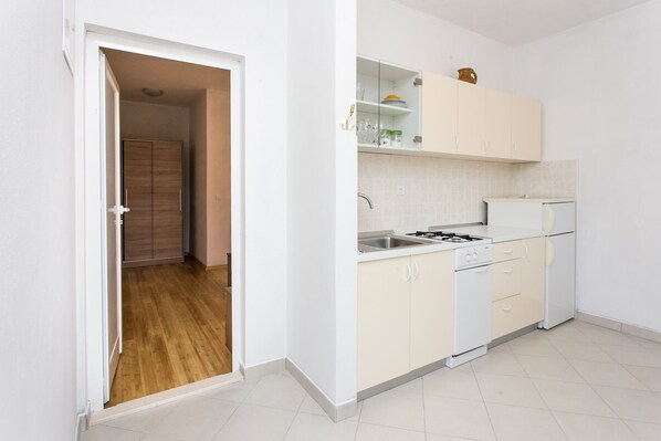 A modern kitchen with white cabinets, a built-in oven, and a refrigerator. - Guest House Oreb - One Bedroom Apartment with Terrace and Sea View (Kolocep)