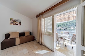 Enjoy a scenic view from the large window in this cozy space, featuring a sofa, artwork, and dining area.