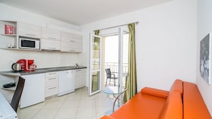 A compact kitchen with a microwave, coffee maker, and a small dining area with a table and chairs.