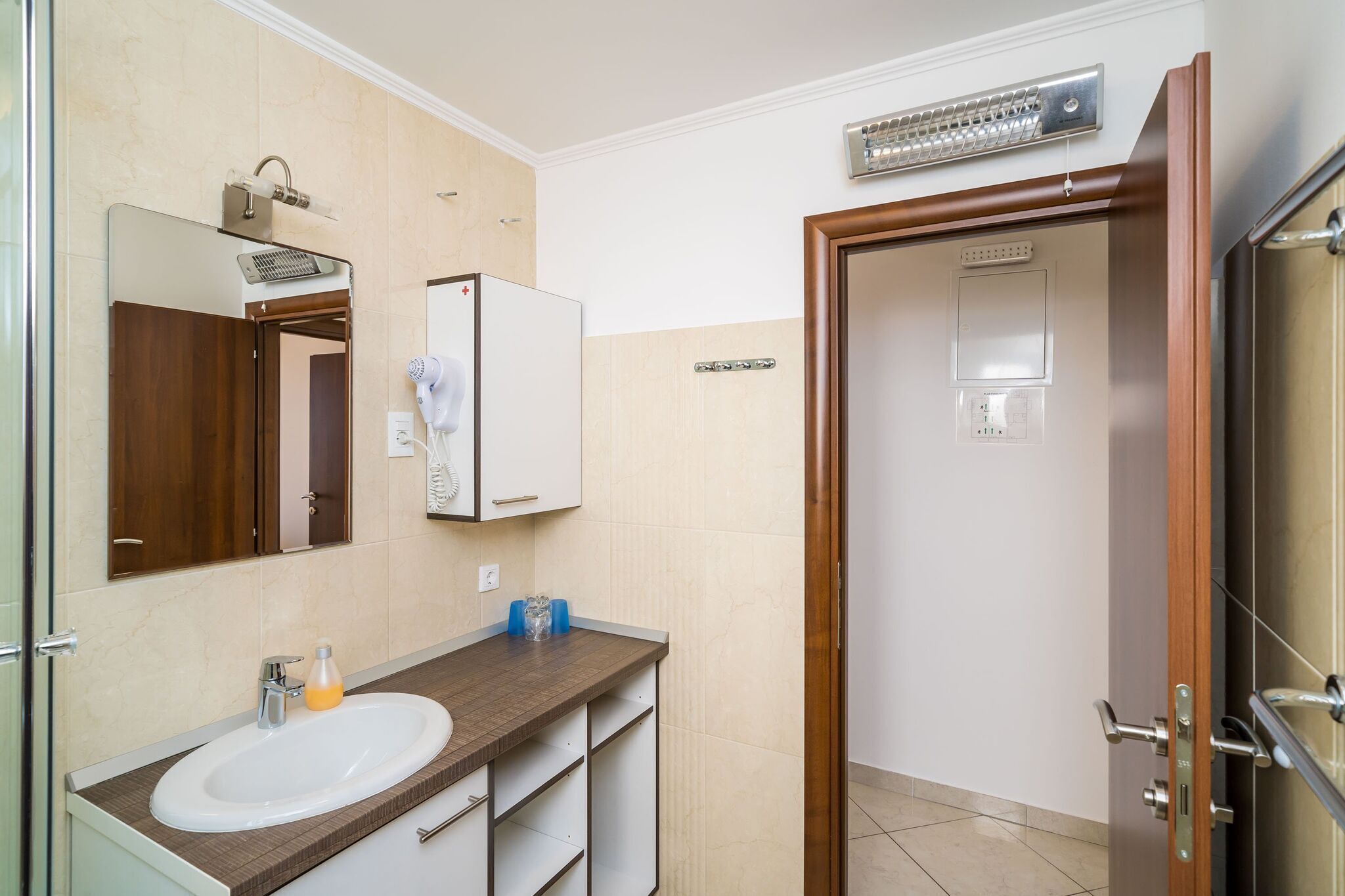Een moderne badkamer met een wastafel, spiegel en handdoekrek.