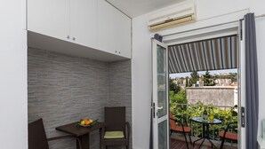 A balcony with a table, chairs, and a view of the city.