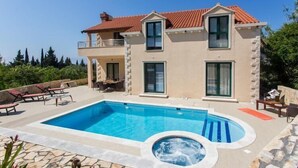Una casa de dos pisos con piscina y jacuzzi.