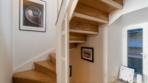 A wooden staircase with a framed artwork above it.