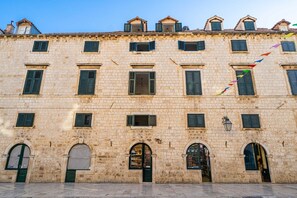 A historic stone building with multiple windows and arched doorways, likely a commercial establishment.