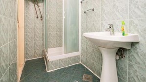 A bathroom with a shower, a sink, and a toilet.