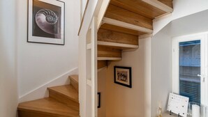 Una escalera con escalones de madera y una obra enmarcada en la pared.