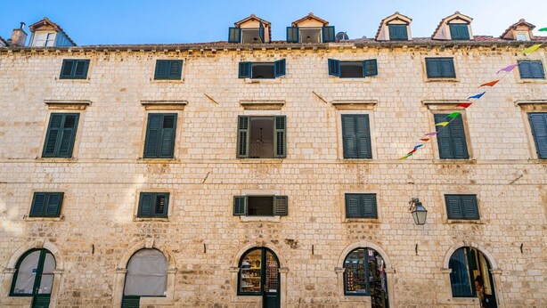 Un edificio histórico de piedra con múltiples ventanas y arcos.
