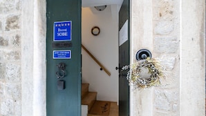 Entrada de hotel con un cartel que indica una calificación de 4 estrellas, una escalera que da al interior y un felpudo en la base.