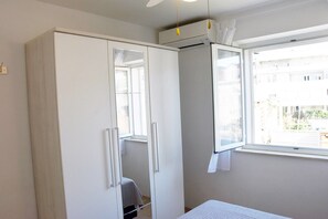 Ein Schlafzimmer mit Kleiderschrank, Fenster und Bett.