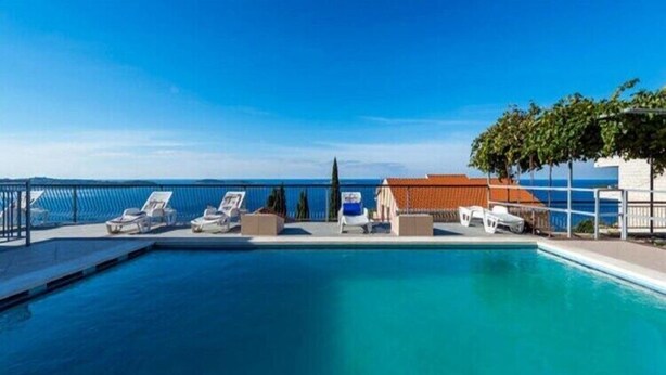 A swimming pool with lounge chairs and a view of the sea. - Apartments Klis -Studio Apartment with Terrace - 2 (C) (Soline)