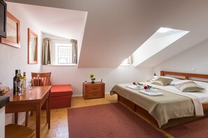 Une chambre à coucher comprenant un lit, un bureau, une chaise, une commode et une fenêtre avec des rideaux.