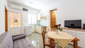 A compact living space with a sofa, dining table, and kitchen area.