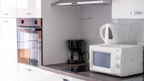 A modern kitchen with a built-in oven, a coffee maker, and a microwave.