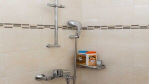 A shower with a chrome faucet, a handheld showerhead, and a shelf with toiletries. - Rooms Batina- Standard Double Room-2 (Dubrovnik)