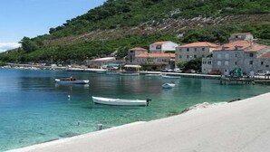 Une ville côtière avec des bâtiments qui bordent le front de mer, des bateaux amarrés et une vue dégagée sur la mer.