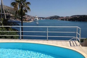 Une piscine offrant une vue dégagée sur la mer et un phare visible au loin.