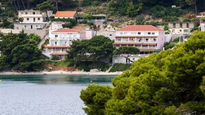 A coastal residential area with buildings close to the water, featuring balconies and a beach in the background. - Apartments Franka Saplunara-One-Bedroom Apartment with Terrace and Sea View No1 (Saplunara)