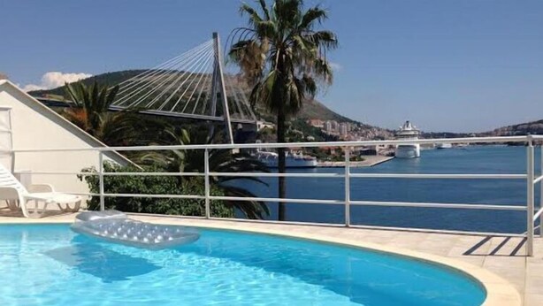 Una piscina con vistas a un puente y una montaña al fondo.