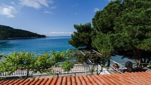 A coastal view with a clear sky, a body of water, and a tree-lined terrace. - Apartments Franka Saplunara-Twin Room with Terrace and Sea view  No1 (Saplunara)