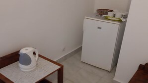 A small kitchenette with a white refrigerator, a kettle on a table, and a microwave on the counter. - Apartments Franka Saplunara-Twin Room with Terrace and Sea view  No1 (Saplunara)