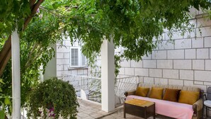 An outdoor seating area with a sofa and table, surrounded by greenery and a white railing. - Guest House Ljubica - Double Room with Private Bathroom-2 (Dubrovnik)