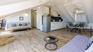 A modern loft apartment with a kitchen, dining area, and living space.