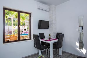 Enjoy meals in this dining area with a flat-screen TV, comfortable seating, and a view of the pool.