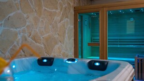 Eine Steinsäule, eine Holztür und ein Whirlpool mit Bedienfeldern.