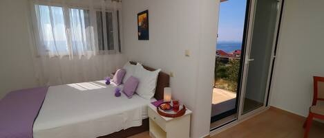 Un dormitorio con cama, mesita de noche y vistas al exterior.