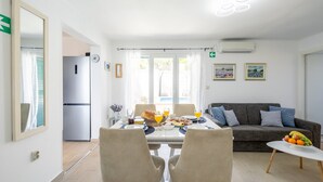 Un espace repas moderne avec une table mise pour le petit-déjeuner, un canapé et une vue sur l’extérieur.
