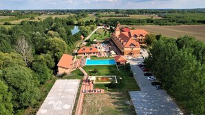 A large hotel with multiple buildings, a swimming pool, and a parking area.