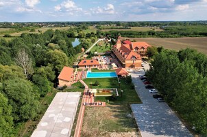 A large hotel with multiple buildings, a swimming pool, and a parking area.