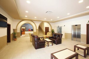 A lobby with a reception desk, seating area, and elevators.