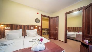 A hotel room with a bed, a wooden headboard, a mirror, and a bathroom visible through an open door.