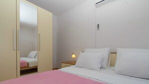 A bedroom with a bed, a nightstand, a lamp, and a wardrobe. - House Green Side Sunset- Four Bedroom House with Pool and Sea View (Prigradica)