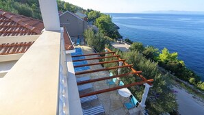 A terrace with a pool, wooden pergola, and a view of the sea. - House Green Side Sunset- Four Bedroom House with Pool and Sea View (Prigradica)