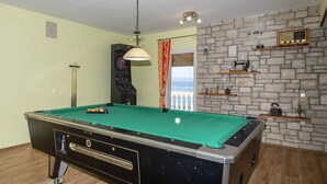 A pool table with a green felt surface, a dartboard, and a billiards cue rack. - House Green Side Sunset- Four Bedroom House with Pool and Sea View (Prigradica)
