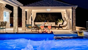 An outdoor pool area with a covered seating area, lounge chairs, and a hot tub. - Villa Blue Sky - Three Bedroom Villa with Pool (Bol)