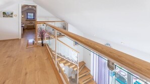 A spacious interior with a wooden staircase leading to a balcony. - Villa Blue Sky - Three Bedroom Villa with Pool (Bol)