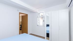 A bedroom with a bed, wardrobe, and a window with a view.