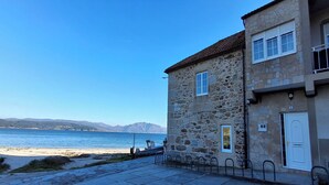 Un edificio de piedra con vistas al mar y a las montañas.