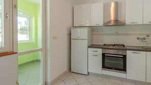 A kitchen with white cabinets, a built-in oven, and a stainless steel range hood.