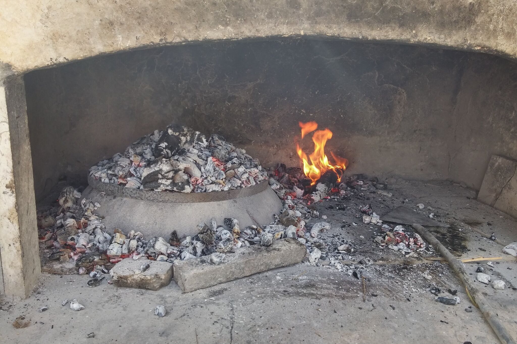 A traditional wood-fired oven with a fire burning inside.